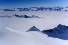 04C Mountains Pop Up From The Surrounding Glacier From Airplane Flying From Union Glacier Camp To Mount Vinson Base Camp.jpg